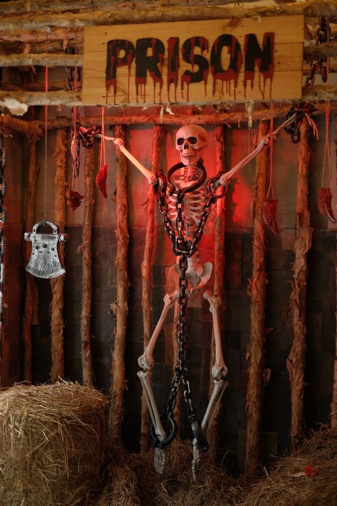 Chilling Halloween display with a skeleton chained in a creepy prison setting. Perfect for festive and spooky themes.